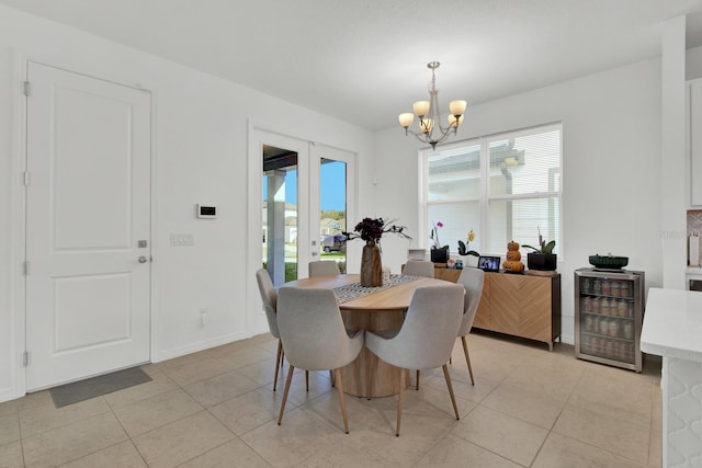 dining area featuring an inviting chandelier, light tile patterned floors, and beverage cooler