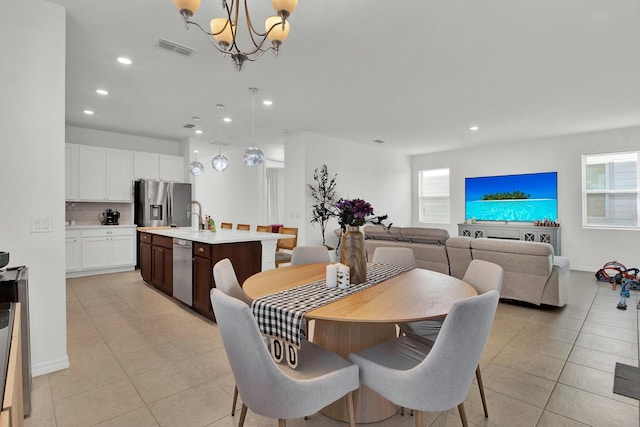 tiled dining room with a notable chandelier