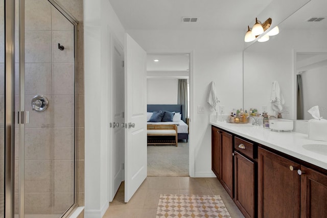 bathroom featuring vanity, a shower with shower door, and tile patterned flooring