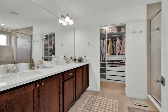 bathroom with a shower with door, tile patterned floors, and vanity