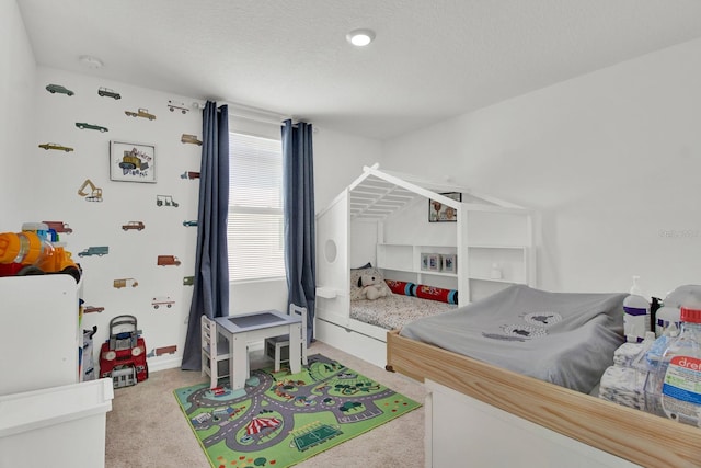 bedroom with a textured ceiling and light colored carpet