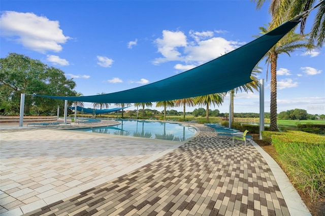 view of pool featuring a patio area and a water view