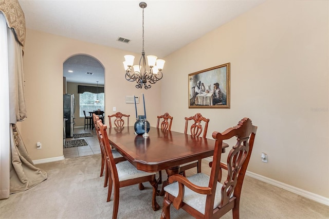 dining space with a notable chandelier and carpet