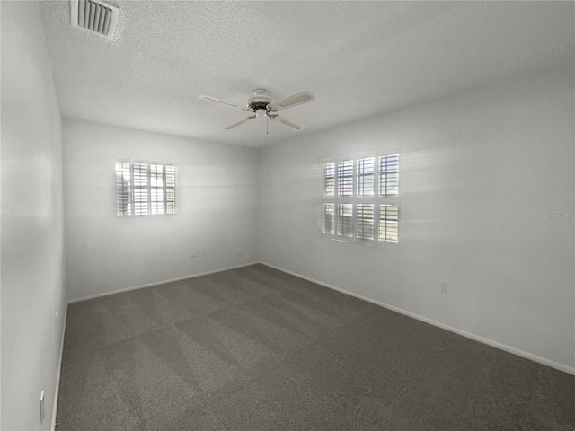 empty room featuring a healthy amount of sunlight and dark carpet