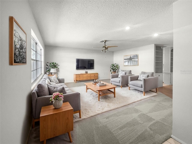 carpeted living room with a textured ceiling and ceiling fan