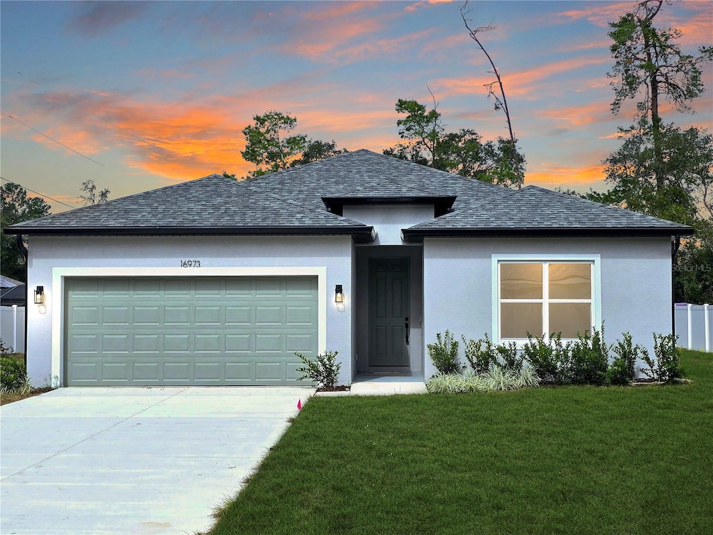 view of front of house with a yard and a garage