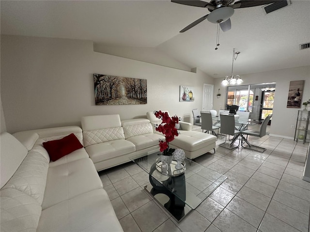 tiled living room with vaulted ceiling and ceiling fan with notable chandelier