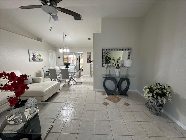 tiled living room featuring vaulted ceiling and ceiling fan with notable chandelier