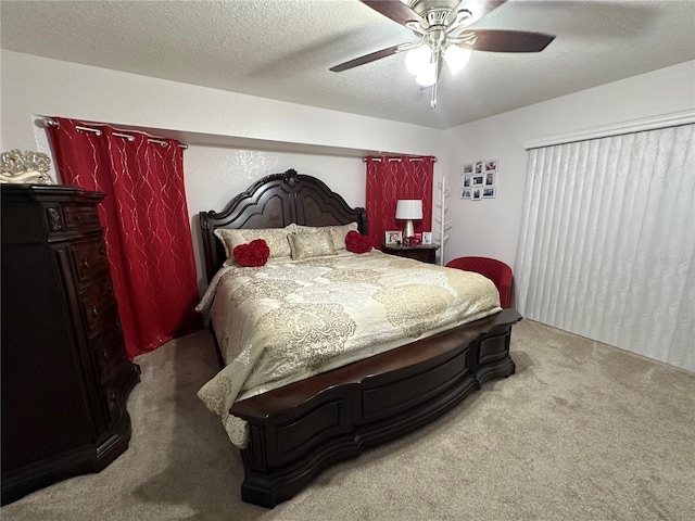 carpeted bedroom featuring ceiling fan and a textured ceiling