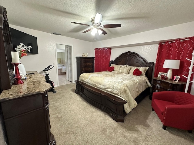 carpeted bedroom featuring ceiling fan, a textured ceiling, and ensuite bathroom