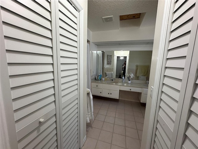 bathroom with vanity, tile patterned floors, and a textured ceiling