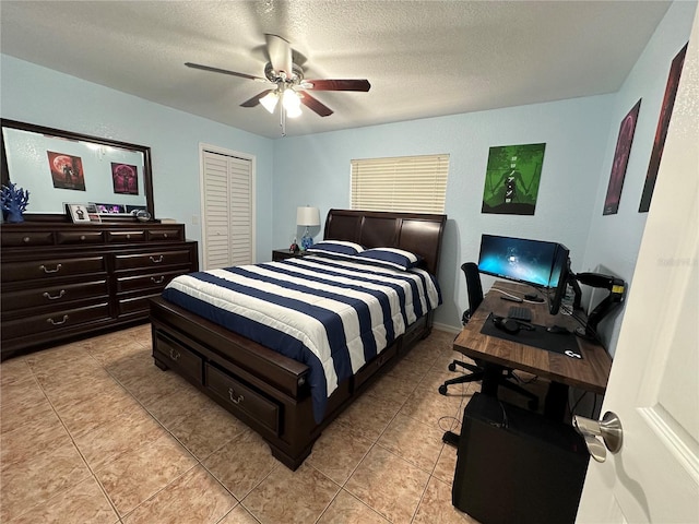 tiled bedroom featuring a textured ceiling, a closet, and ceiling fan