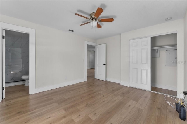 unfurnished bedroom with a closet, light hardwood / wood-style floors, ensuite bathroom, and ceiling fan