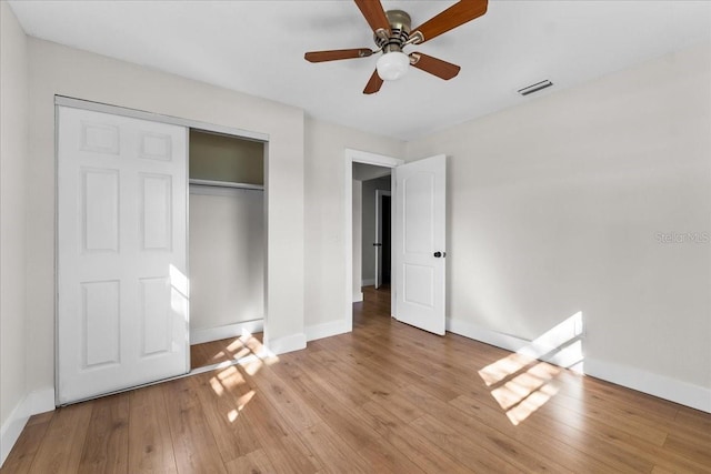 unfurnished bedroom with a closet, light wood-type flooring, and ceiling fan