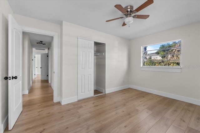 unfurnished bedroom with light hardwood / wood-style flooring, a closet, and ceiling fan