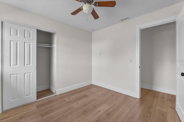 unfurnished bedroom with light hardwood / wood-style flooring, a closet, and ceiling fan