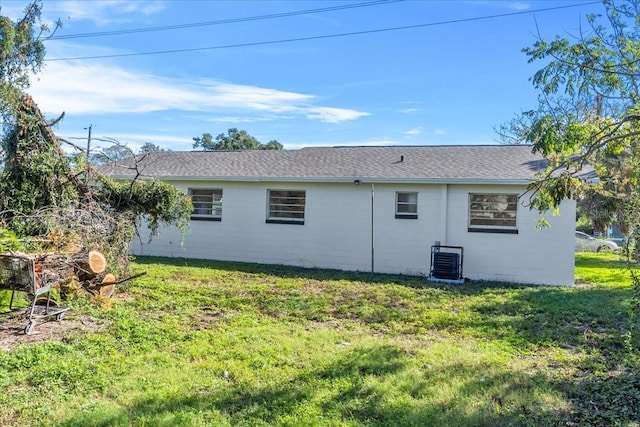 exterior space with central AC unit and a lawn