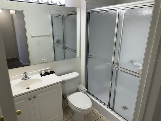 bathroom with toilet, walk in shower, vanity, and tile patterned floors