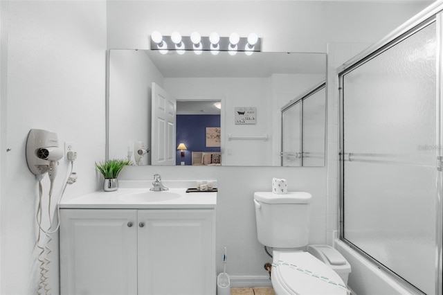 full bathroom featuring vanity, bath / shower combo with glass door, toilet, and tile patterned floors