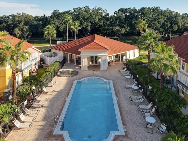 view of swimming pool with central air condition unit and a patio