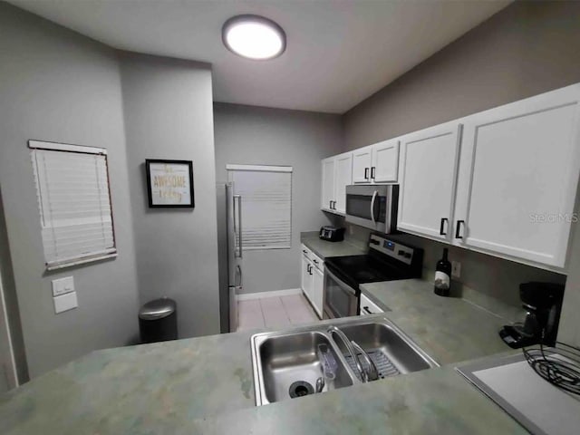 kitchen with stainless steel appliances, white cabinets, and sink