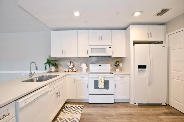 kitchen with white appliances, sink, light wood-type flooring, tasteful backsplash, and white cabinetry