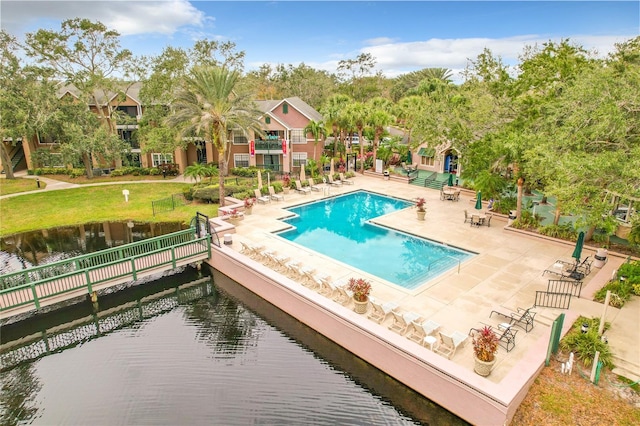 view of pool with a patio area and a water view