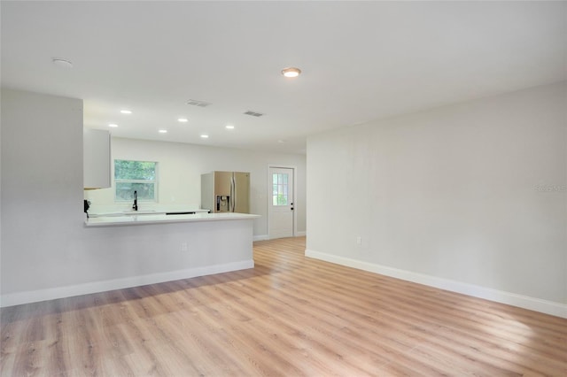 unfurnished room featuring light hardwood / wood-style floors and sink