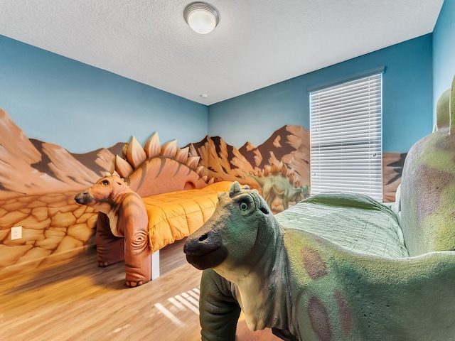 bedroom with wood-type flooring and a textured ceiling