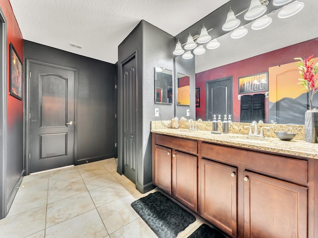 bathroom featuring tile patterned flooring, a textured ceiling, and vanity