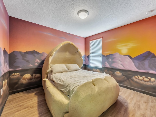 bedroom featuring hardwood / wood-style floors and a textured ceiling