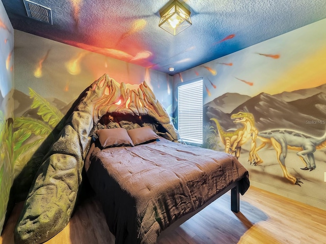 bedroom with a textured ceiling and light wood-type flooring