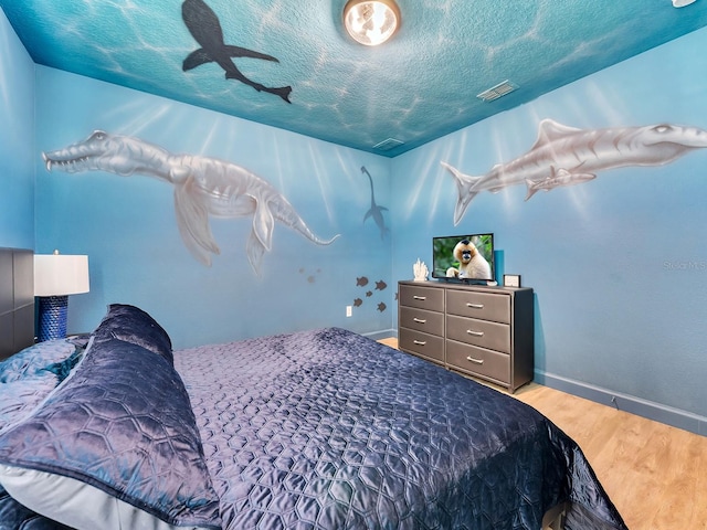 bedroom featuring hardwood / wood-style flooring and a textured ceiling