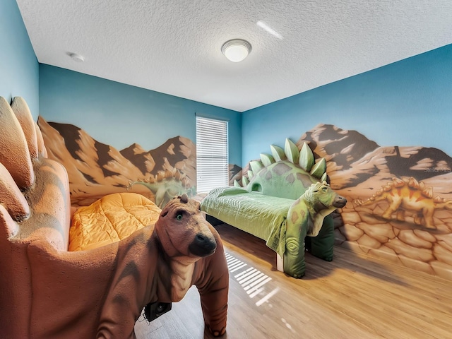 bedroom with hardwood / wood-style floors and a textured ceiling