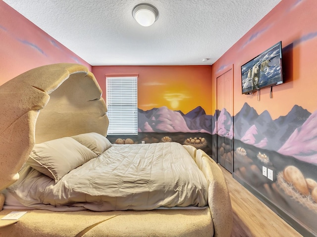 bedroom with wood-type flooring and a textured ceiling