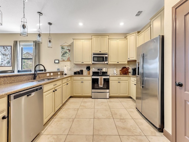 kitchen featuring sink, stainless steel appliances, pendant lighting, decorative backsplash, and light tile patterned floors