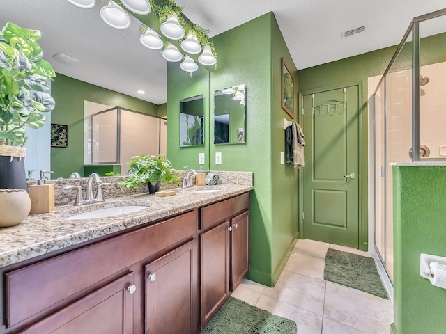 bathroom featuring tile patterned flooring, vanity, and a shower with shower door