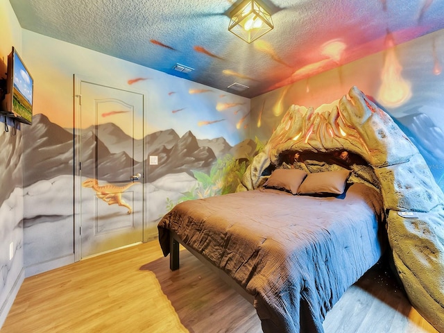 bedroom with a closet, wood-type flooring, and a textured ceiling