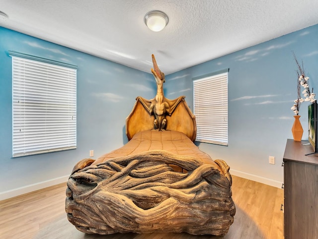 bedroom featuring a textured ceiling and light wood-type flooring