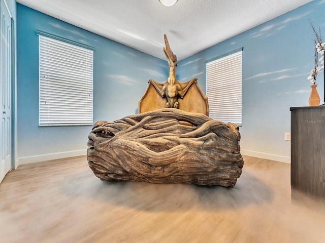 bedroom with light wood-type flooring and a textured ceiling