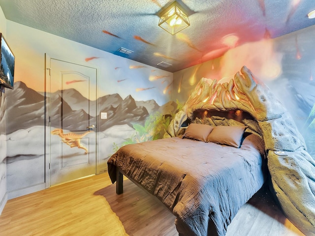 bedroom featuring a closet, wood-type flooring, and a textured ceiling