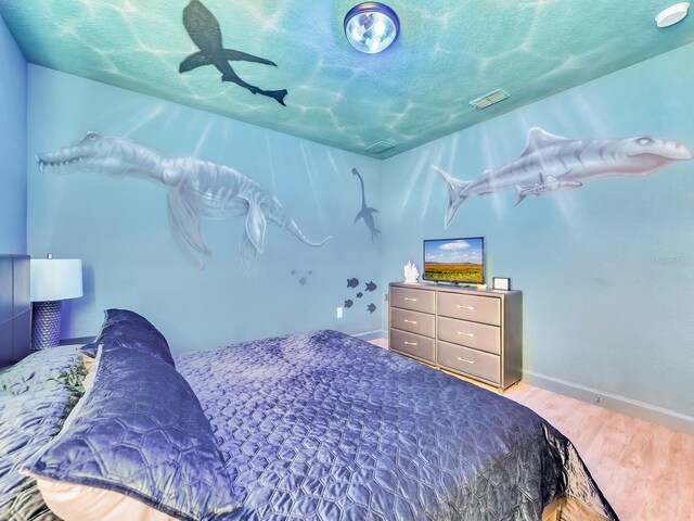 bedroom featuring hardwood / wood-style flooring and a textured ceiling