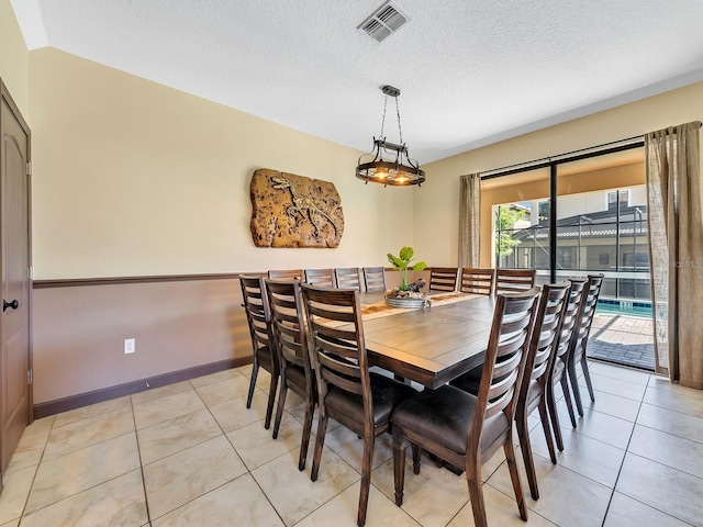 dining room featuring light tile patterned floors and a textured ceiling