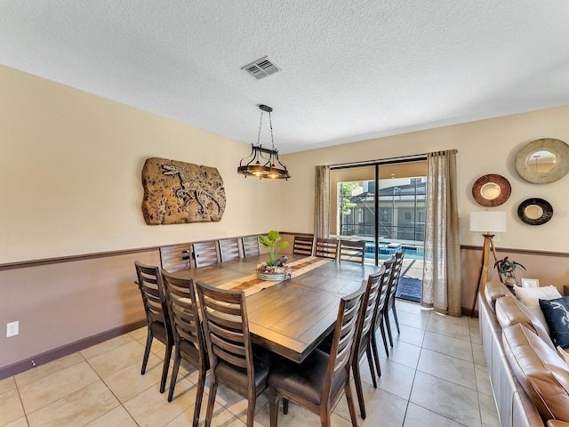 dining room featuring light tile patterned floors and a textured ceiling