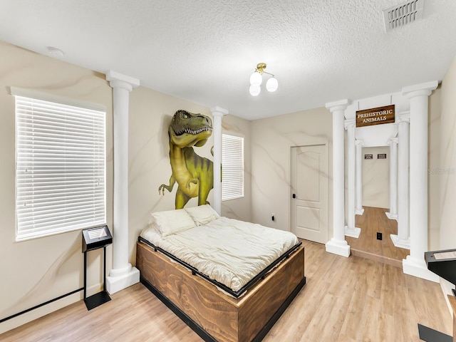 bedroom with a textured ceiling and light wood-type flooring