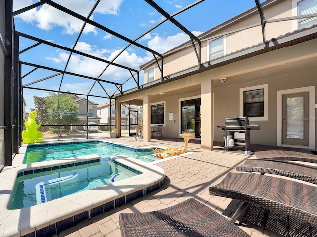 view of pool with a lanai, grilling area, an in ground hot tub, and a patio