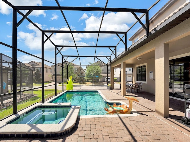 view of pool with an in ground hot tub, glass enclosure, and a patio area