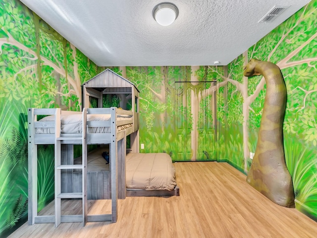 unfurnished bedroom featuring hardwood / wood-style floors and a textured ceiling