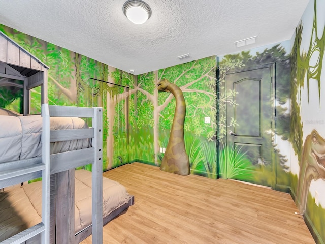 bedroom with wood-type flooring and a textured ceiling