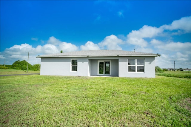 rear view of property featuring a yard